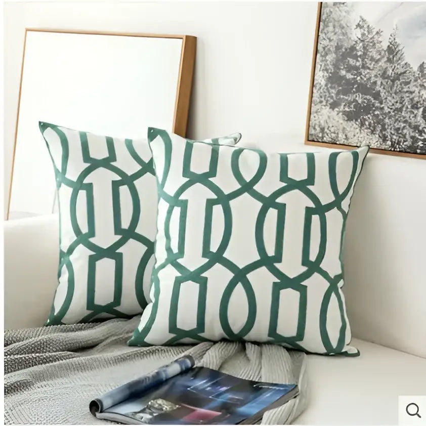 Two green and white geometric patterned throw pillows with decorbites embroidered blue cotton cushion cover for living room