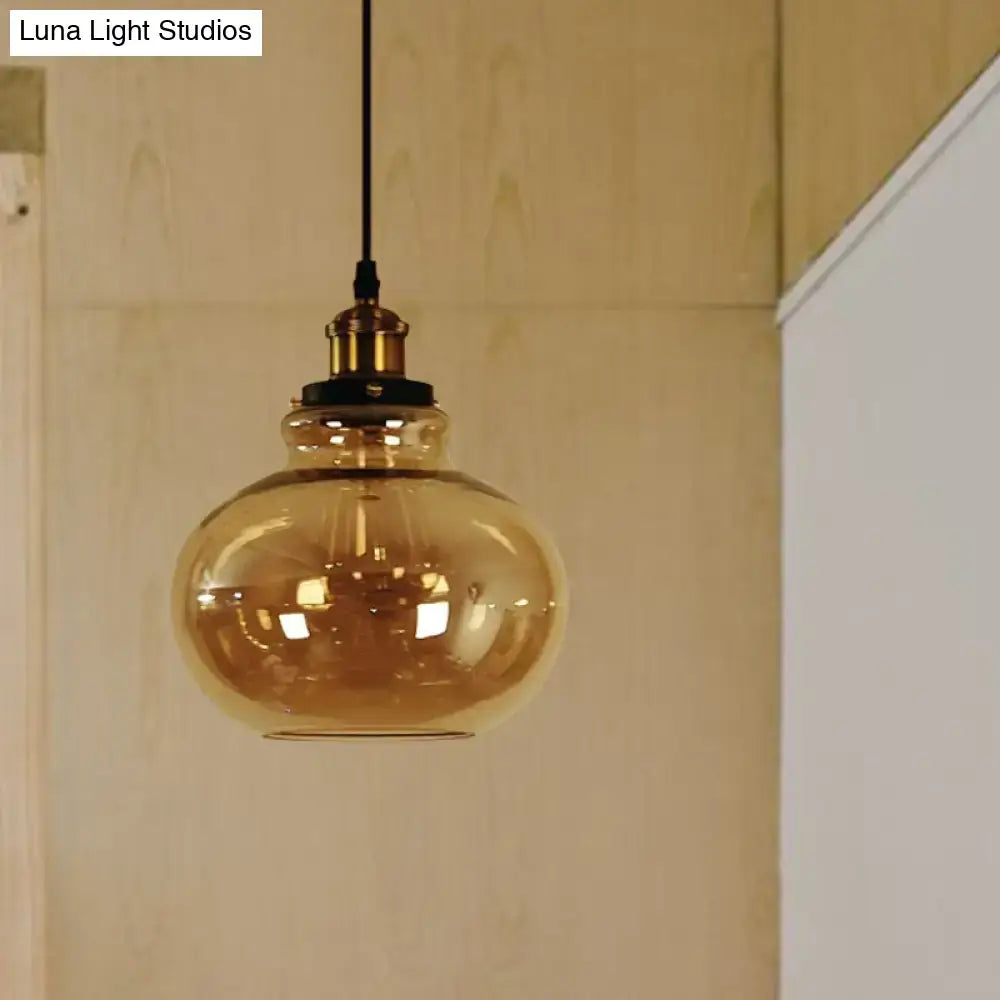 Decorbites farmhouse brass pendant ceiling light featuring an amber glass globe with brass fixture and black cord for indoor use