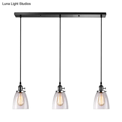 Black metal pendant light with linear canopy and three clear glass ribbed shades featuring exposed filament bulbs