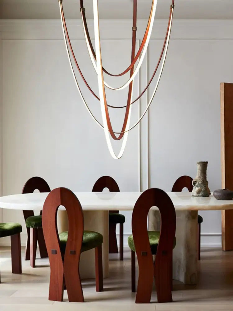 DecorBites flexible leather belt LED chandelier featuring layered curved leather straps in brown and cream tones