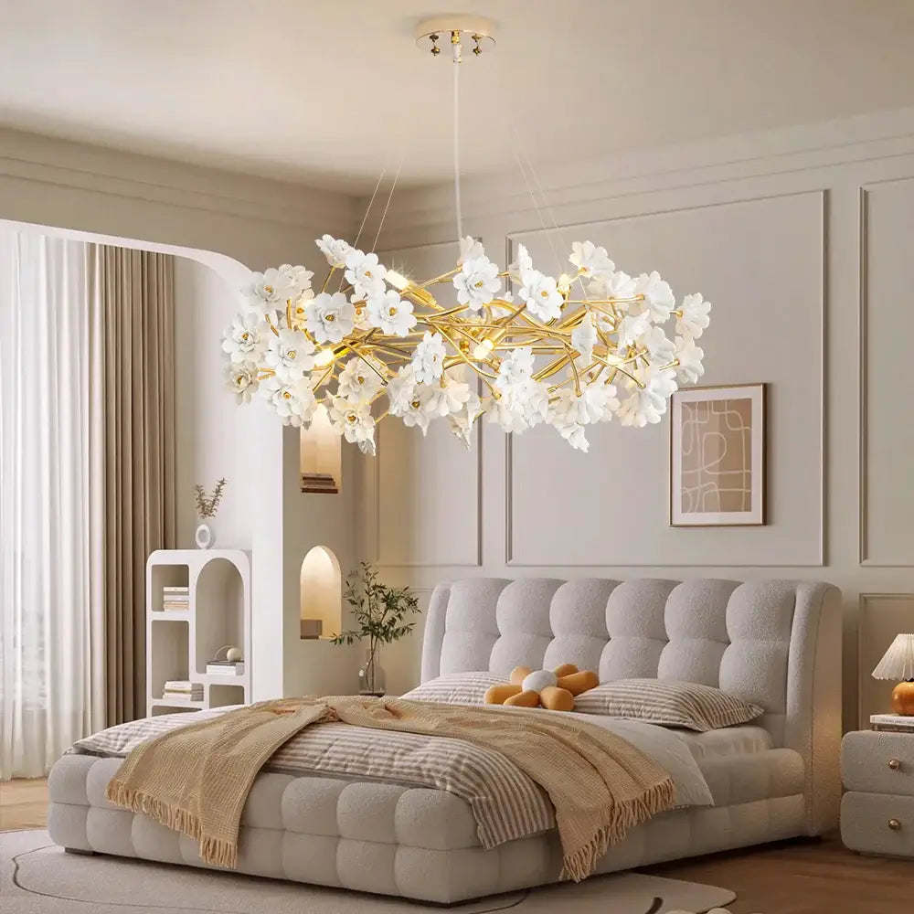 Elegant decorbites™ floral french white ceramic chandelier with gold-toned branches and white flower chandelier design above tufted bed