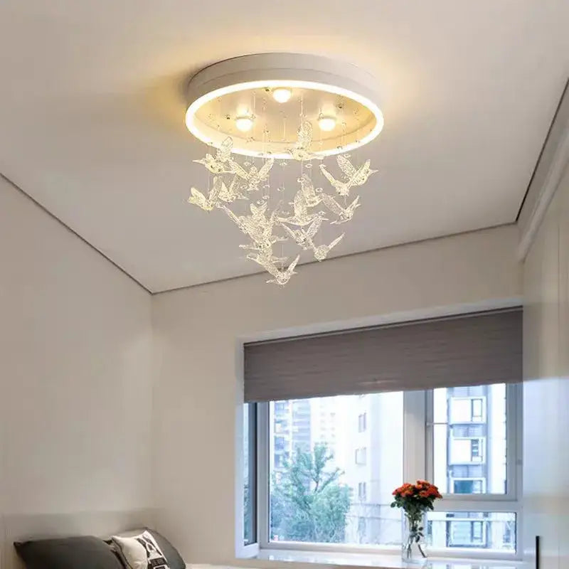 A modern white decorbites flying bird ceiling light with crystal bird ornaments and embedded bulbs for bedroom use
