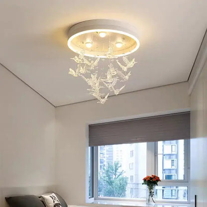 A modern white decorbites flying bird ceiling light with crystal bird ornaments and embedded bulbs for bedroom use