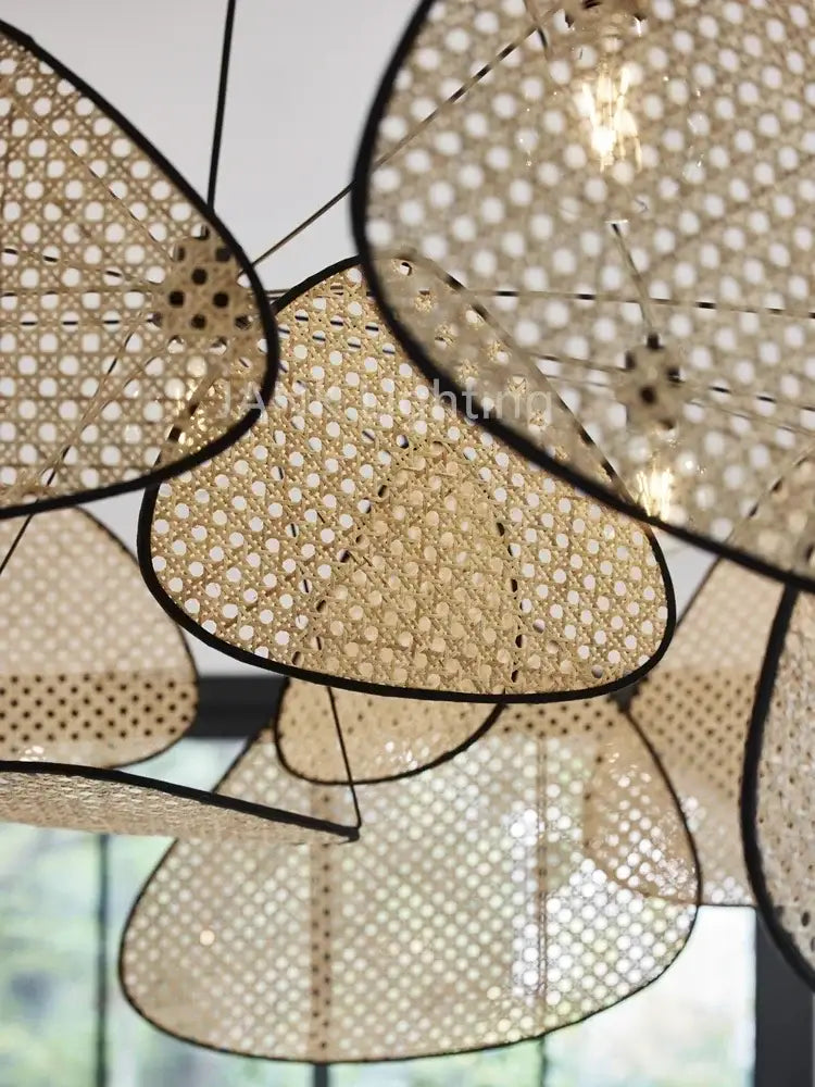 Beige woven rattan chandelier with black-framed leaf-shaped shades from decorbites french design market
