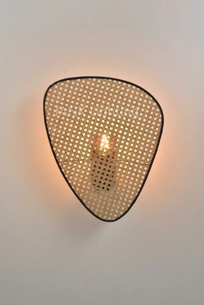A warm-toned teardrop-shaped wall sconce with woven rattan shade and black trim in french design rattan chandelier style