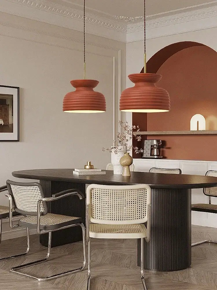 Two terracotta ribbed pendant lights showcasing decorbites french minimalist chandelier design above dining table