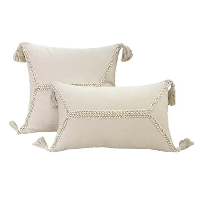 Cream-colored rectangular throw pillows with braided rope trim and tassels from decorbites fringed geometry cushion cover