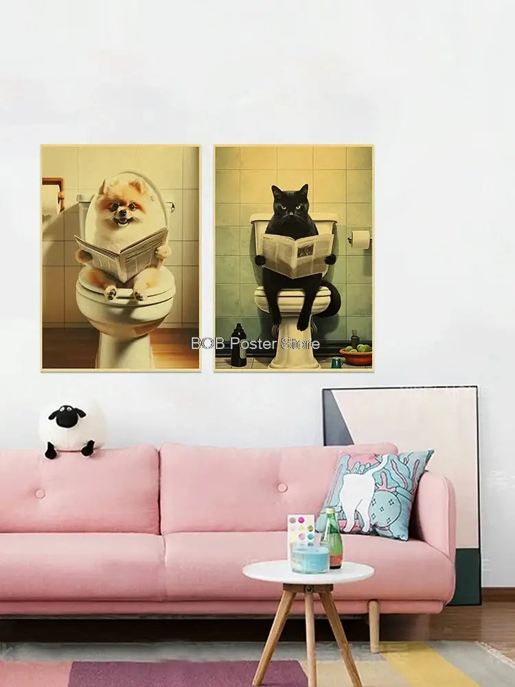 Two framed vintage-style animal bathroom posters featuring a pomeranian and black cat on toilets above a pink sofa for home decor