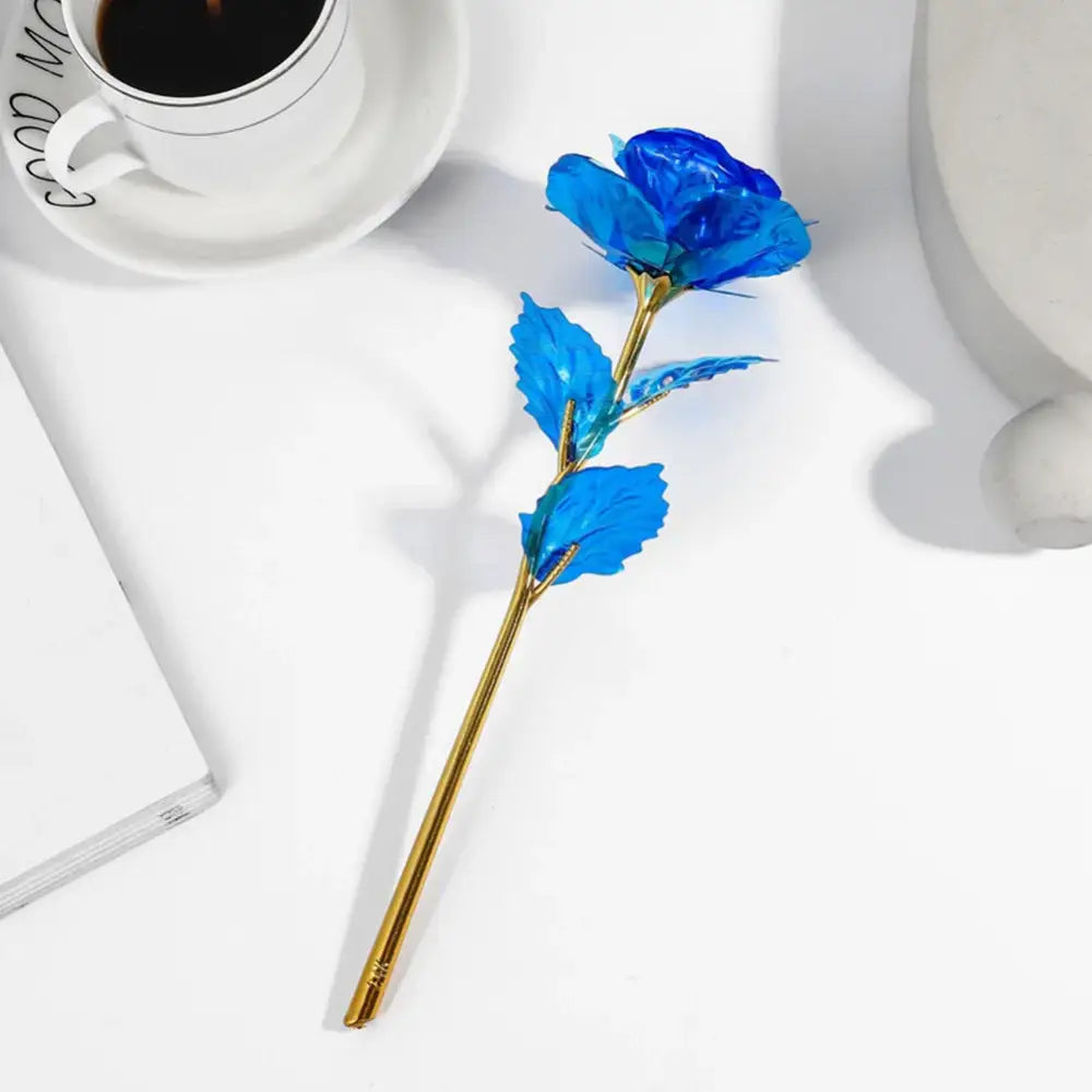A decorbites galaxy rose centerpiece featuring a vibrant blue rose with translucent petals and a golden stem