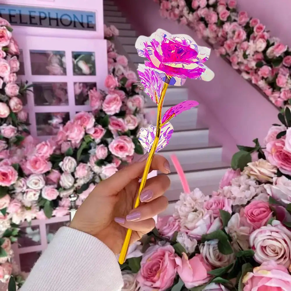 A decorbites galaxy rose metallic centerpiece with vibrant pink and white petals and a golden stem against floral decor