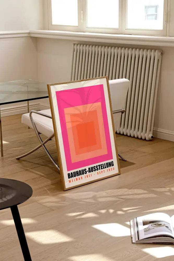 Framed geometric bauhaus wall art with concentric pink and orange squares and black bauhaus-ausstellung text for home decor