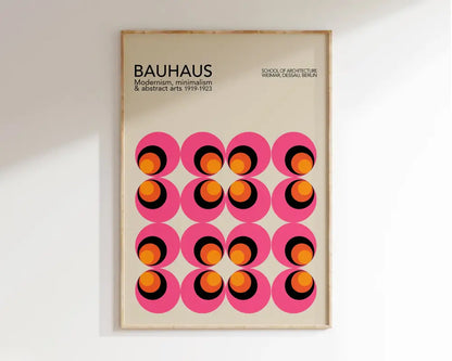 A framed bauhaus mid century wall art geometric canvas print with vibrant pink circles and orange black rings