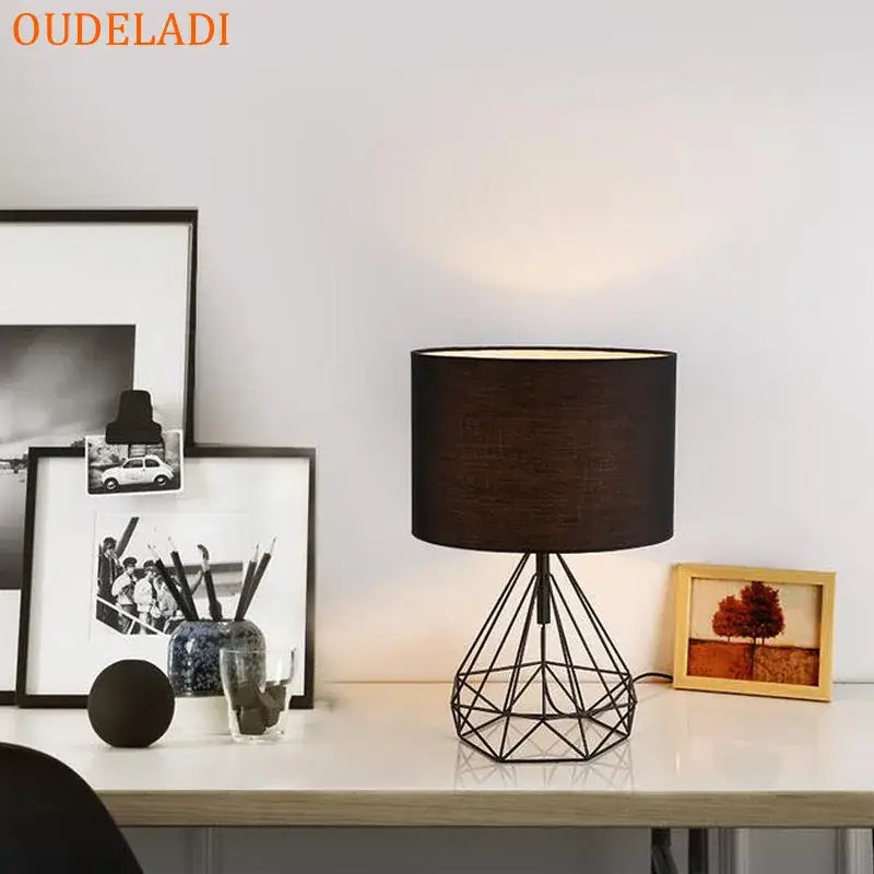Black geometric wireframe table lamp with matte black cylindrical shade by decorbites geometric gold desk lamp collection