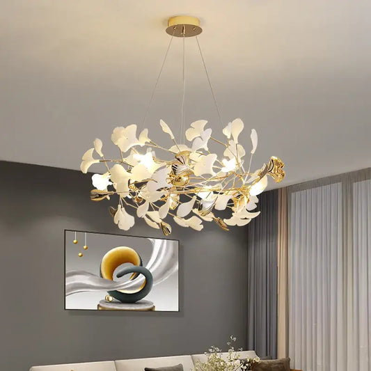 Gold-toned decorbites ginkgo leaf chandelier with delicate white glass leaves and modern branching design for living room