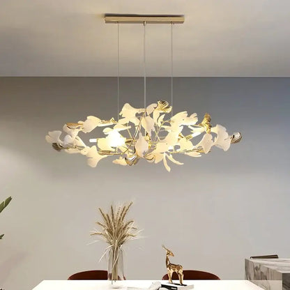 A modern gold and white decorbites ginkgo leaf chandelier pendant light with sleek metallic ceiling mount for living areas