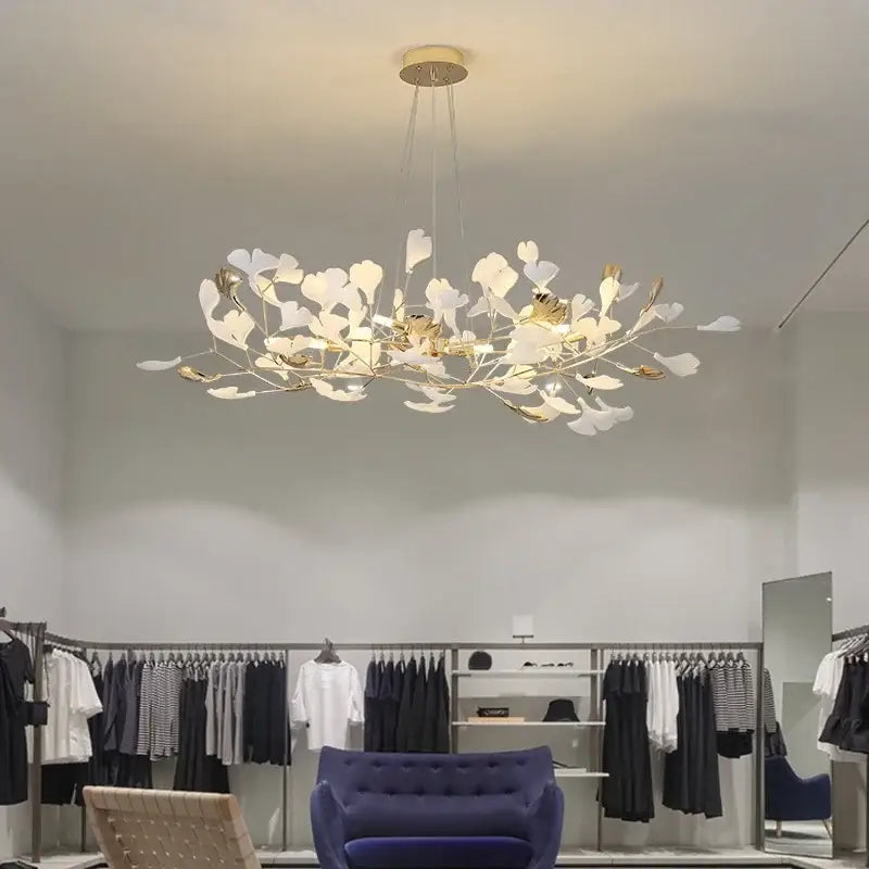 A modern DecorBites Ginkgo Leaf pendant chandelier with delicate white and gold leaf-shaped accents for living room decor