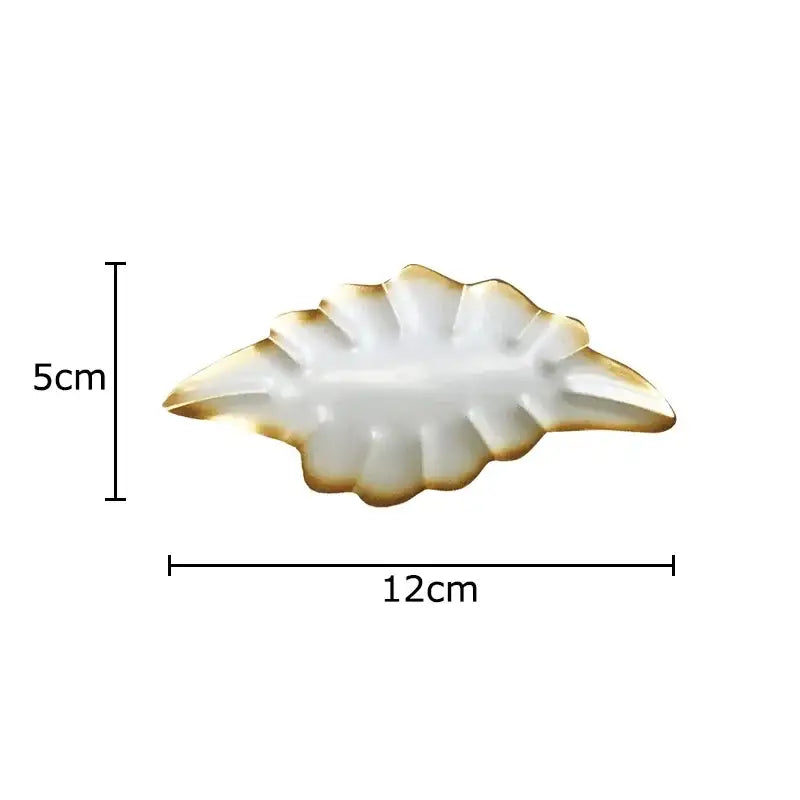 A white ceramic leaf-shaped dish with gold trim from decorbites ginkgo leaves wall decor for living room ornaments