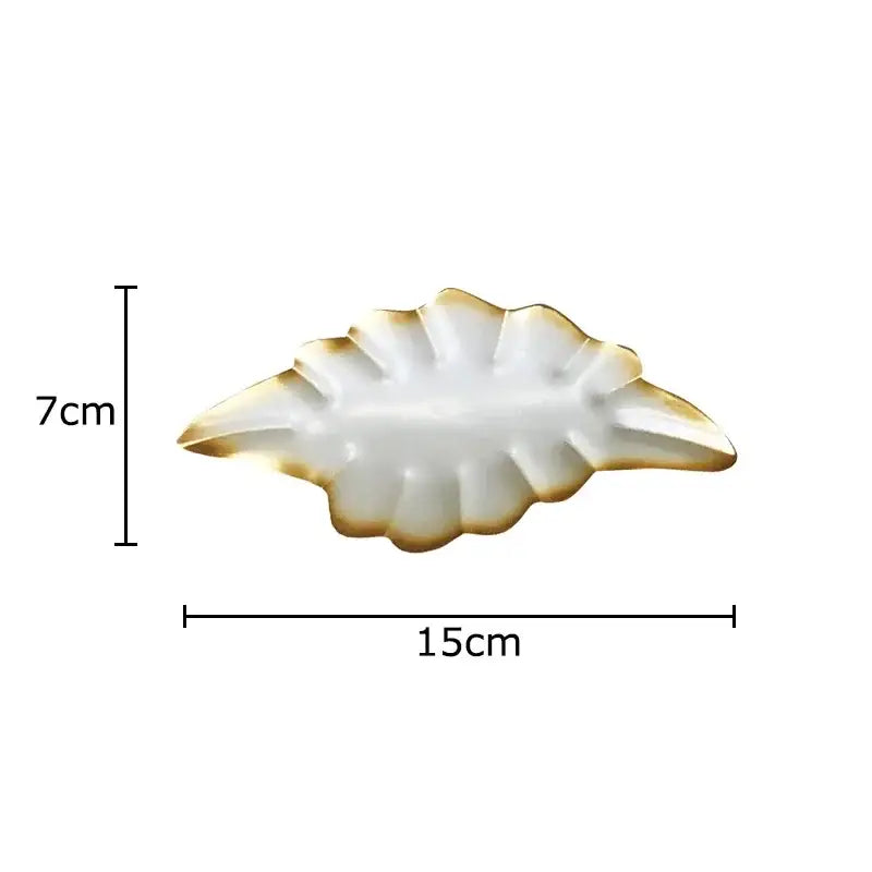 A white ceramic DecorBites™ ginkgo leaf wall hanging ornament with gold trim for living room decor