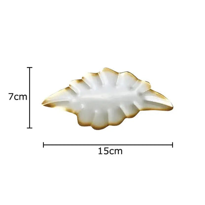 A white ceramic DecorBites™ ginkgo leaf wall hanging ornament with gold trim for living room decor