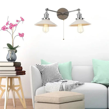 Decorbites glass 2-light wall sconce with pull chain switch features brushed nickel arms, cream shades, and exposed edison bulbs