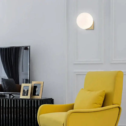 A sleek decorbites glass ball wall lamp with frosted glass globe and gold metal base for bedroom aisle lighting