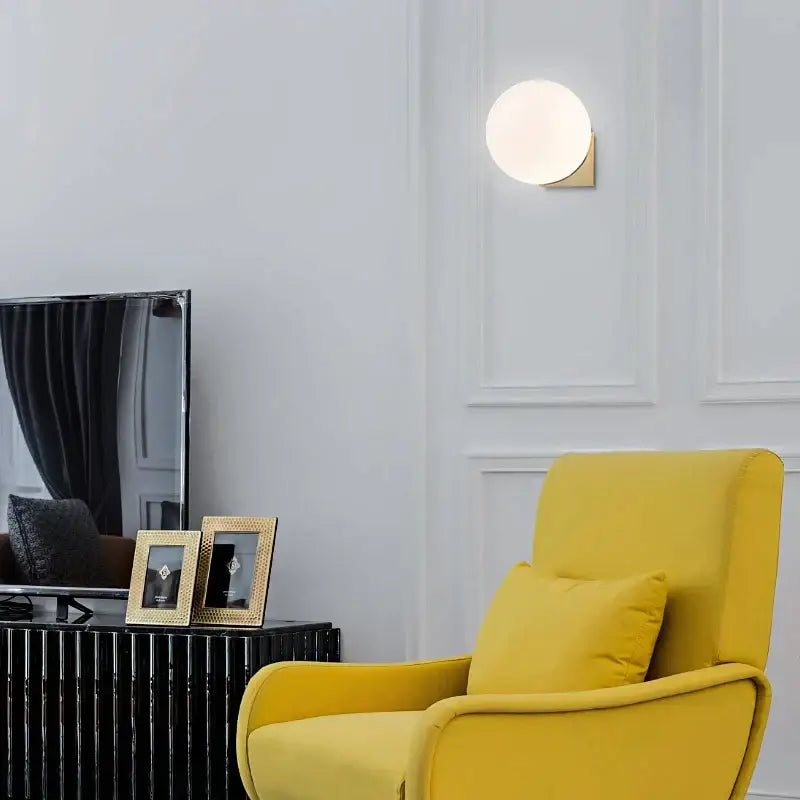 A sleek decorbites glass ball wall lamp with frosted glass globe and gold metal base for bedroom aisle lighting