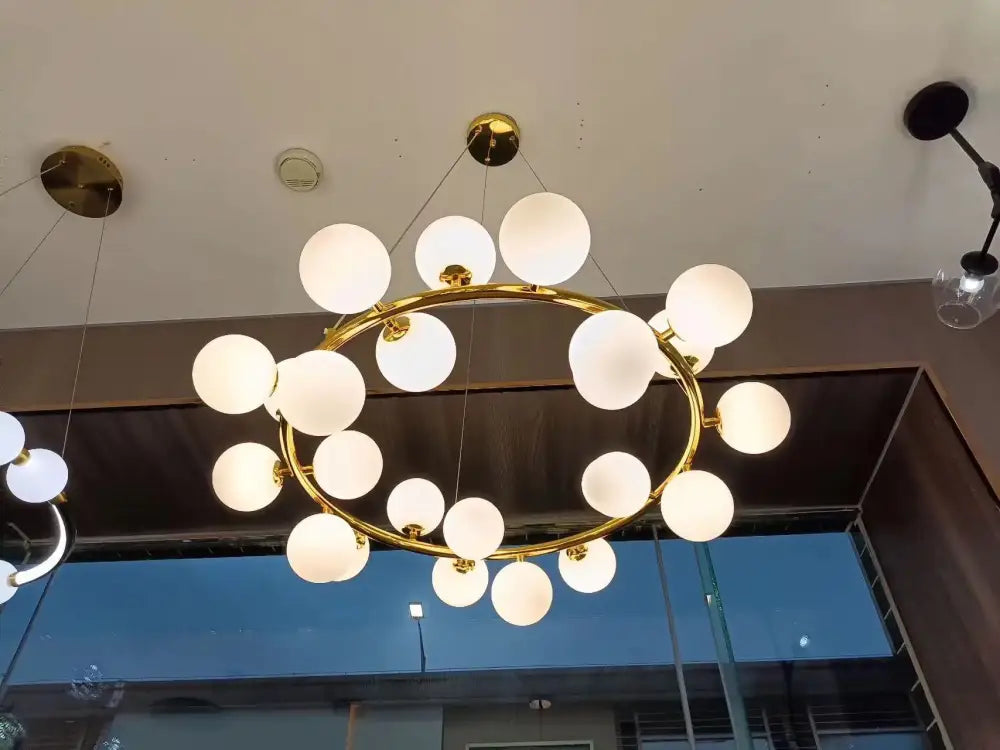 Gold-toned DecorBites glass ball ceiling chandelier with frosted glass globe bulbs for dining and living room decor