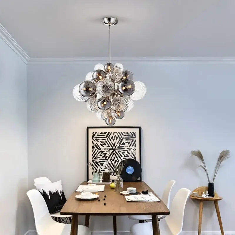 A modern decorbites glass ball ceiling chandelier with reflective silver and clear glass bulbs for living room lighting