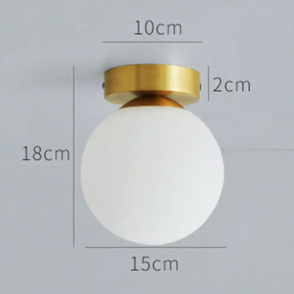 A sleek decorbites glass ball ceiling light with a frosted white glass ball shade and polished brass mounting ring