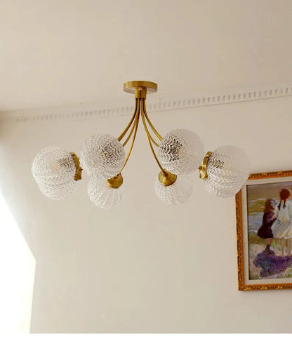 A brass decorbites glass ball ceiling light with five clear textured glass globe shades for modern living spaces