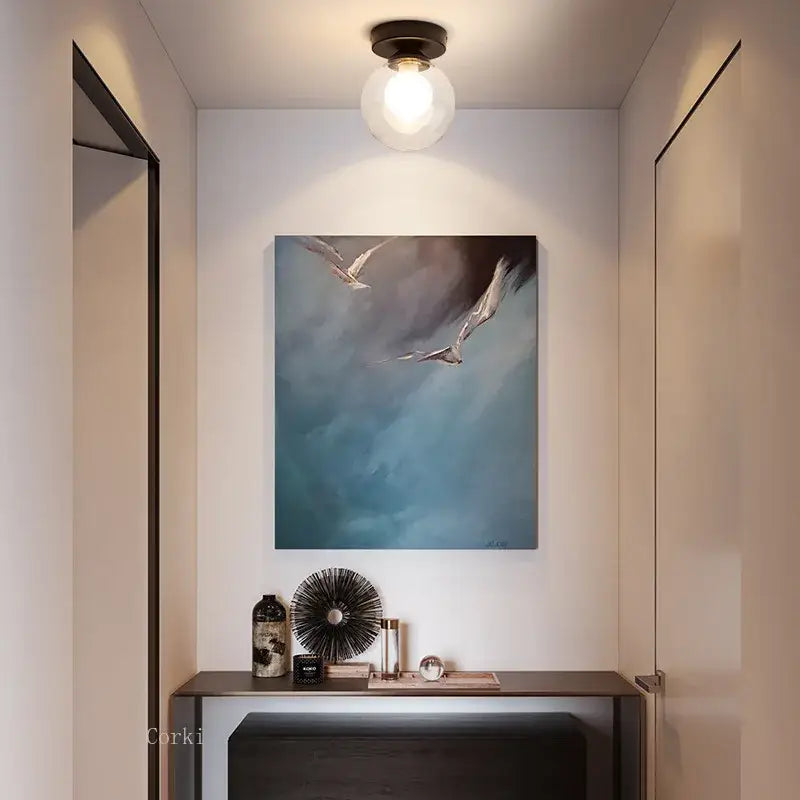 Modern nordic decorbites glass ball ceiling light with abstract white birds painting above dark console table wall