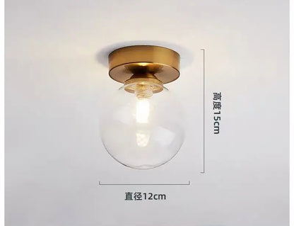 DecorBites glass ball ceiling light with clear glass globe and brass base measuring 15cm height and 12cm diameter