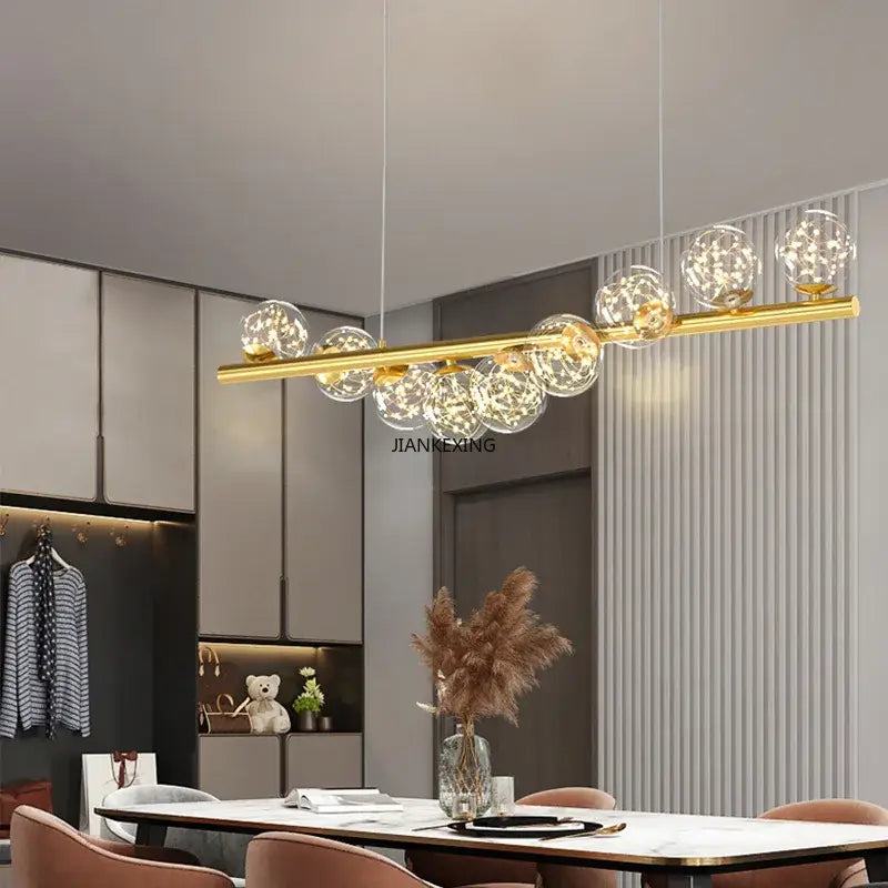 Gold-toned decorbites glass ball chandelier with clear glass globe bulbs suspended from a sleek horizontal bar