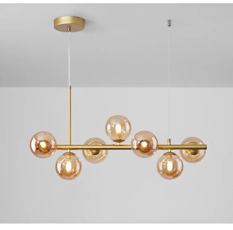 Gold-toned DecorBites™ glass ball chandelier with seven amber glass globe bulbs on a central brass bar for home lighting