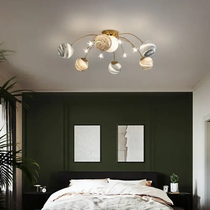 Gold-toned decorbites glass ball chandelier with planet-themed globes and star accents for kids and living rooms