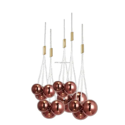 A decorbites glass ball chandelier featuring rose gold metallic spherical ornaments with brass connectors and white cords