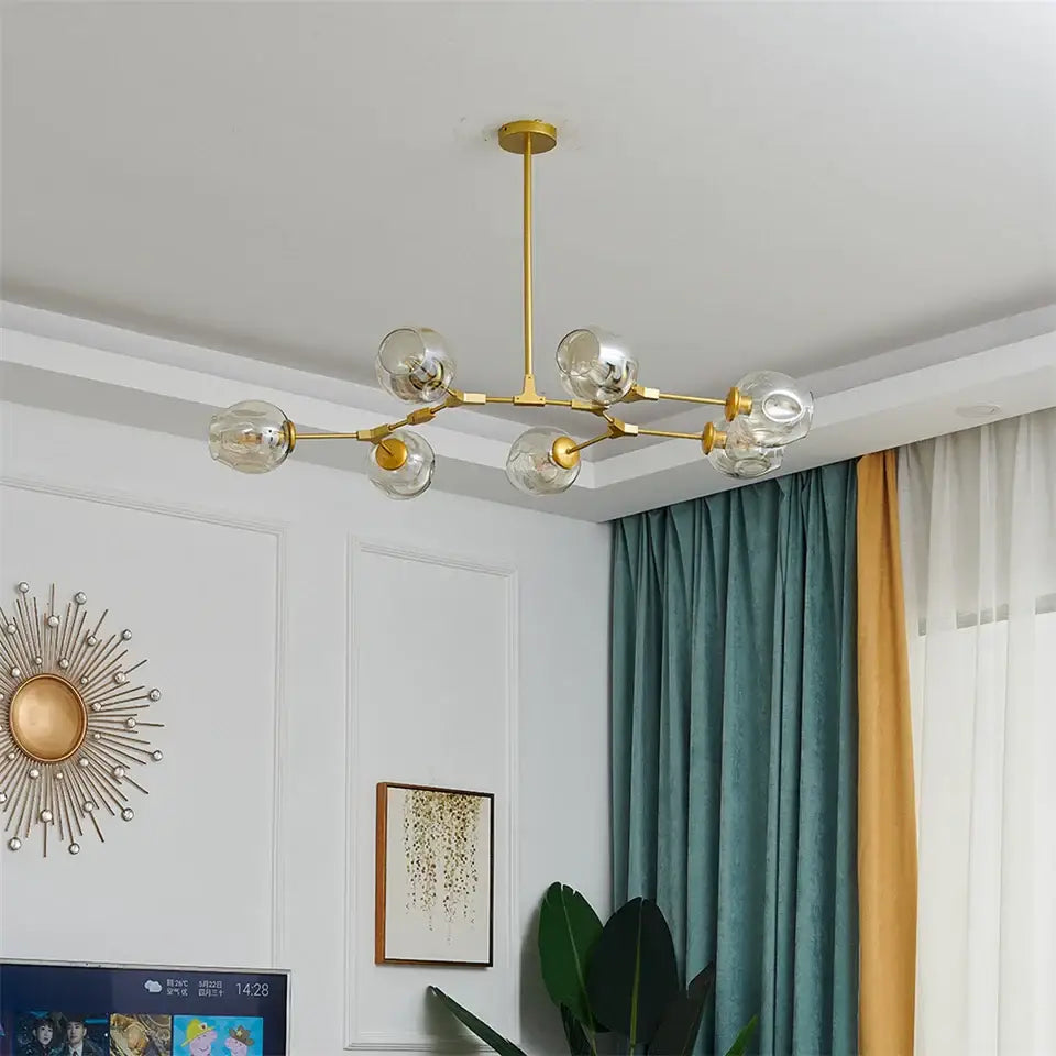 Gold-toned DecorBites glass ball led chandelier with six clear glass globes in a modern nordic style design