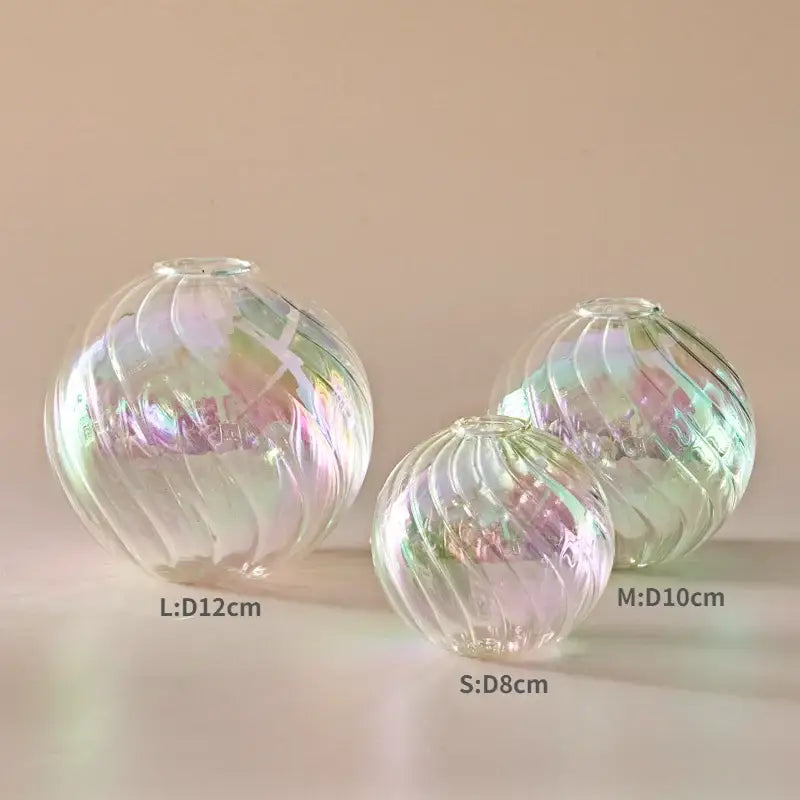 Set of three iridescent glass ball vases with swirling ribbed patterns in small medium and large sizes for home decor