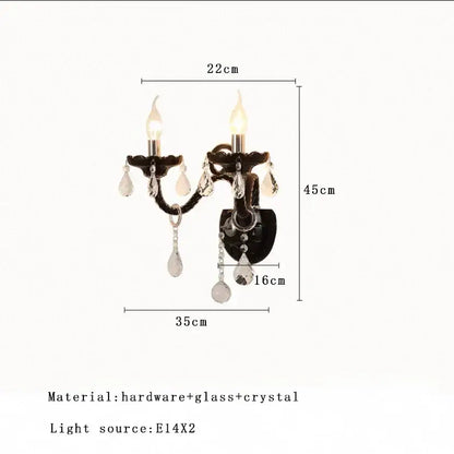 Black wrought iron wall sconce with two candle lights and crystal pendants complementing decorbites glass branch chandelier