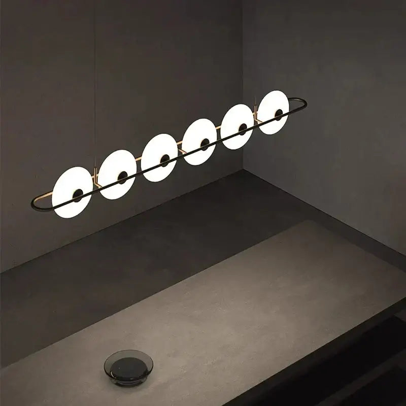 Modern minimalist decorbites glass chandelier with five white diffusers on black metal frame in store exhibition setting