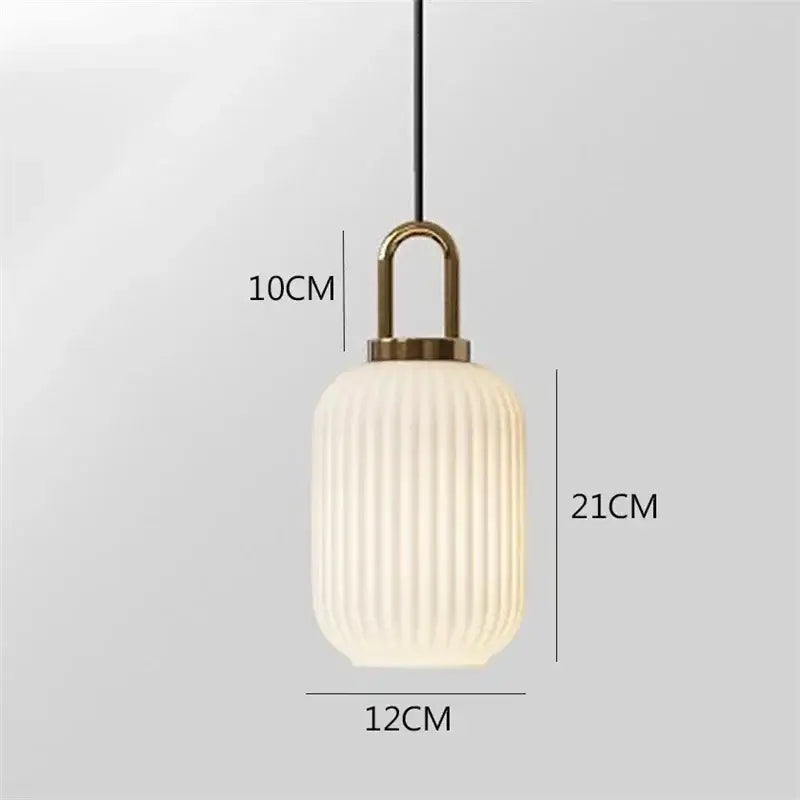 A modern decorbites glass stripe pendant light with frosted white ribbed glass shade and brass top for dining room