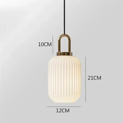 A modern decorbites glass stripe pendant light with frosted white ribbed glass shade and brass top for dining room