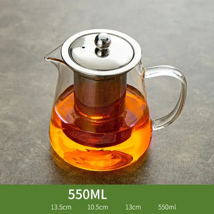 Clear glass tea jug with stainless steel lid and built-in filter filled with amber tea in decorbites™ jug set