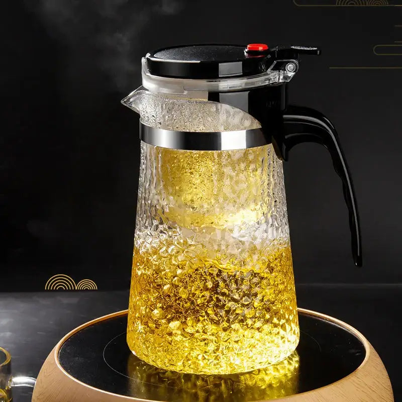 DecorBites glass tea maker with clear textured glass, black lid handle, silver rim, and hammer pattern filter for brewing tea