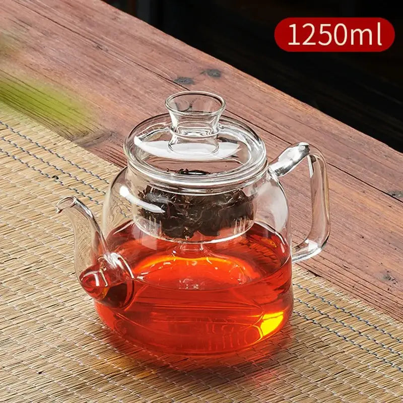 Clear glass tea pot with lid and handle filled with amber tea from decorbites glass tea pot set with filterable kettle
