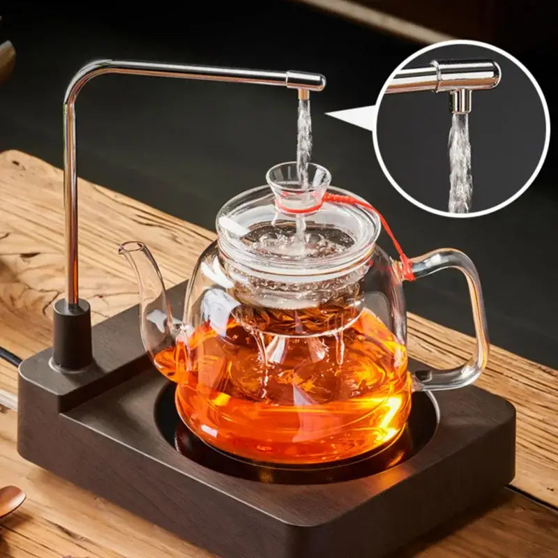 Clear glass tea pot with stainless steel spout and handle filled with amber tea from decorbites™ tea pot set