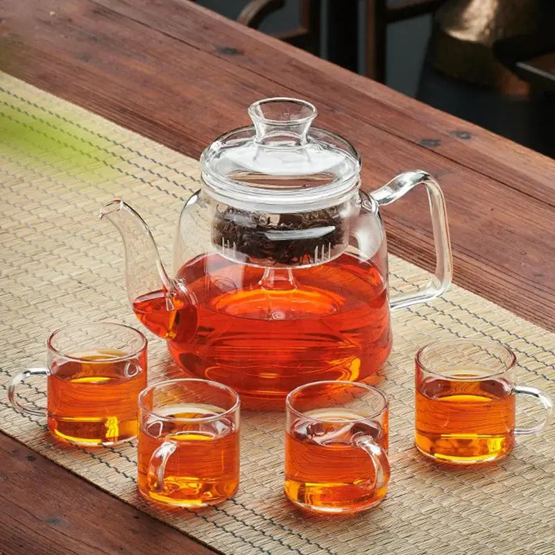 Decorbites™ glass tea pot set with high quality filterable clear glass kettle filled with amber tea and four matching cups