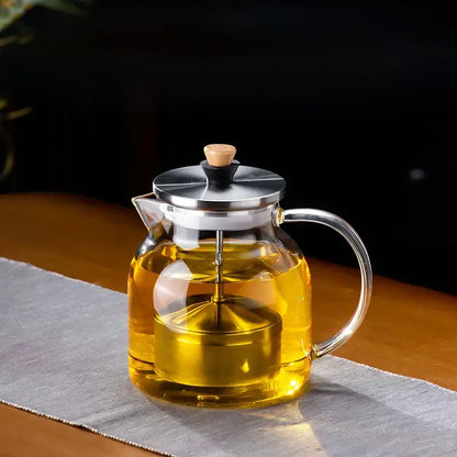 DecorBites glass tea pot with a clear glass body, stainless steel lid and handle, and wooden knob for herbal tea