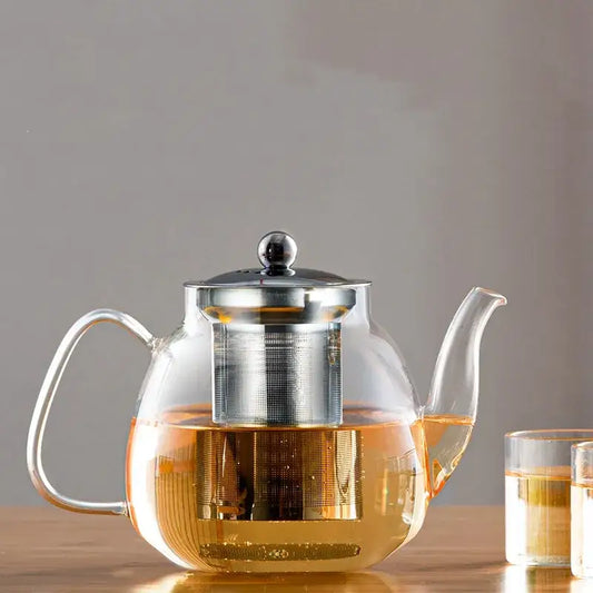 DecorBites™ glass tea pot with stainless steel lid and built-in filter filled with amber tea for steeping puer and coffee