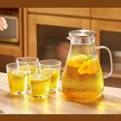 Clear textured glass pitcher with silver lid and handle filled with lemon tea from decorbites glass tea set